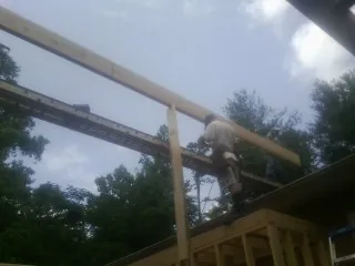 Carpenter setting a ridge beam over a new addition frame — Ice Dam Removal by Roofing Brothers in South Pasadena