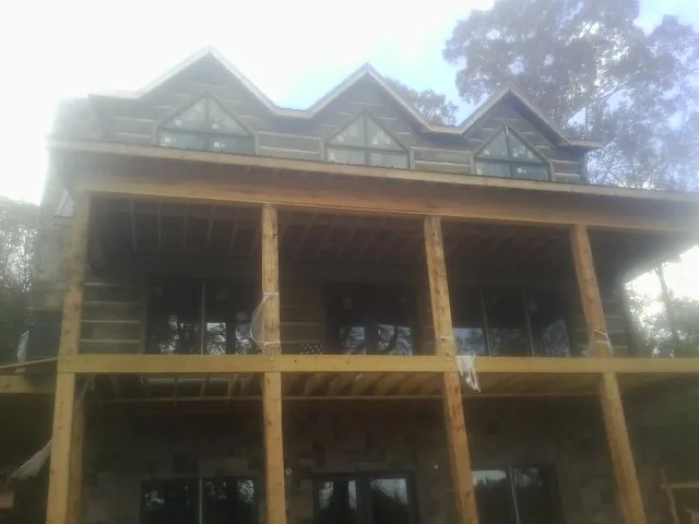 Dormers and porch framing on a large log home under construction — Roof Coating work by our crew in South Pasadena