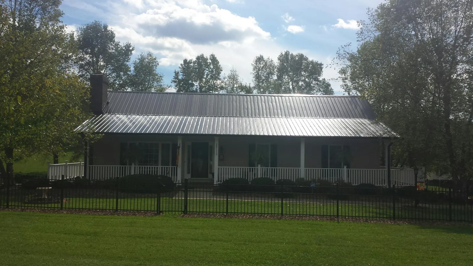 Gray metal roof on a brick ranch with a full width front porch — Gutter Guard Installation work by our crew in South Pasadena
